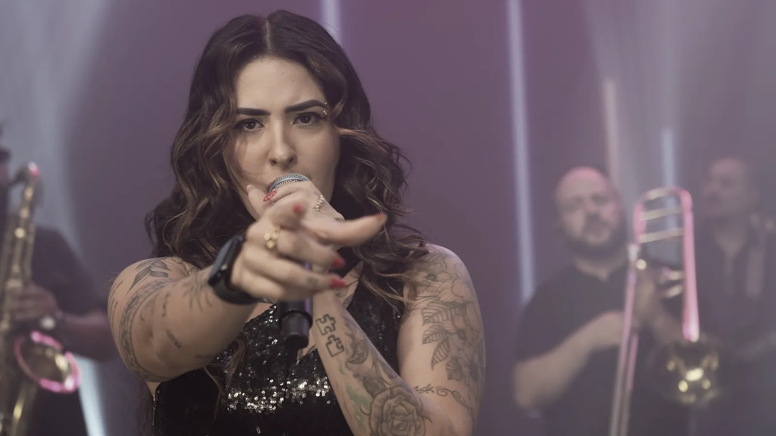 Vocalista da Banda Prime cantando e apontando para o público durante uma festa